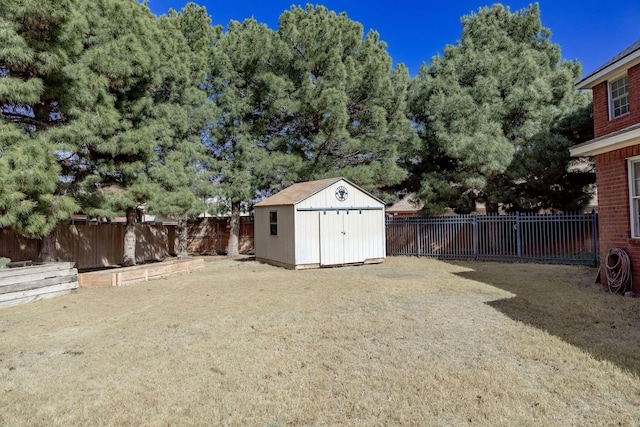 view of yard with a fenced backyard, an outbuilding, and a storage unit