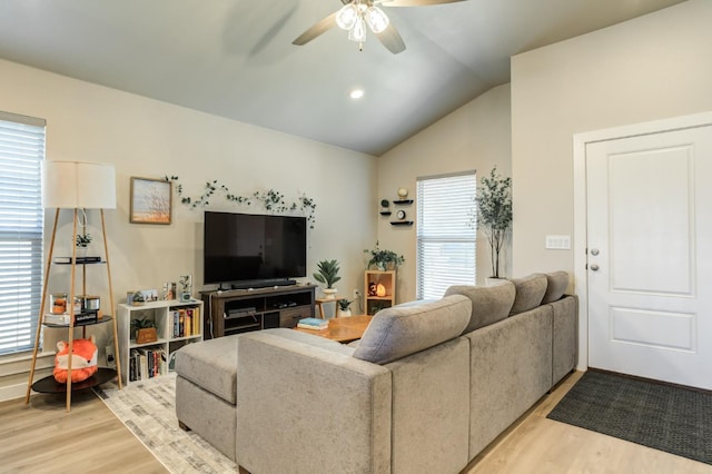 living room featuring a healthy amount of sunlight, lofted ceiling, and light wood-type flooring