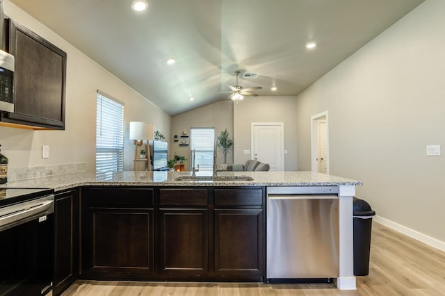 kitchen with stainless steel appliances, kitchen peninsula, sink, and dark brown cabinets