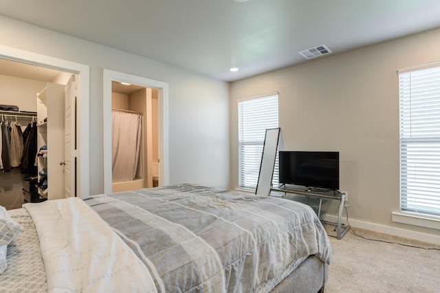 bedroom with multiple windows, carpet, a spacious closet, and a closet