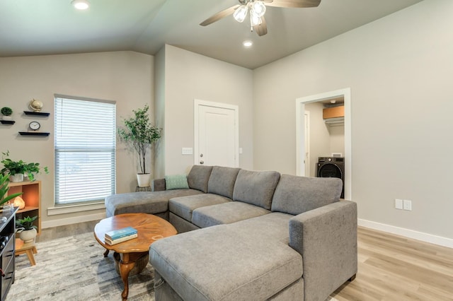 living room featuring lofted ceiling, washer / clothes dryer, ceiling fan, and light wood-type flooring