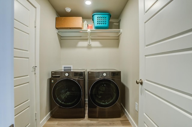 laundry room featuring light wood-type flooring and washer and clothes dryer