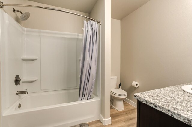 full bathroom featuring hardwood / wood-style flooring, vanity, shower / bathtub combination with curtain, and toilet