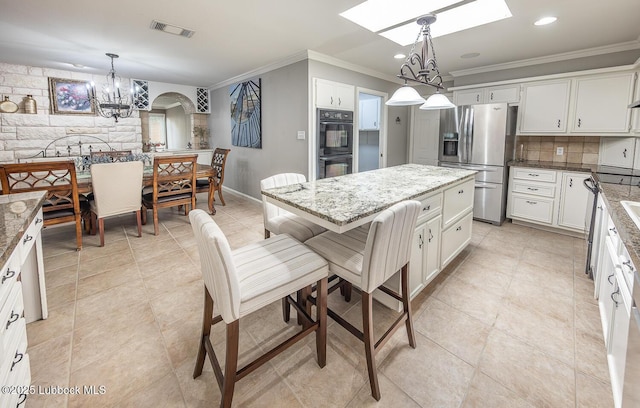 3417 56th St, Lubbock, TX 79413 - kitchen featuring stainless steel fridge with ice dispenser, ornamental molding, a chandelier, a skylight, and light stone counters
