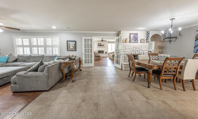 3417 56th St, Lubbock, TX 79413 - dining room with a stone fireplace, ceiling fan, a chandelier, and ornamental molding