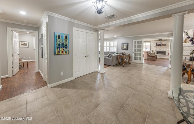 3417 56th St, Lubbock, TX 79413 - foyer with decorative columns, crown molding, a stone fireplace, recessed lighting, and light tile patterned floors