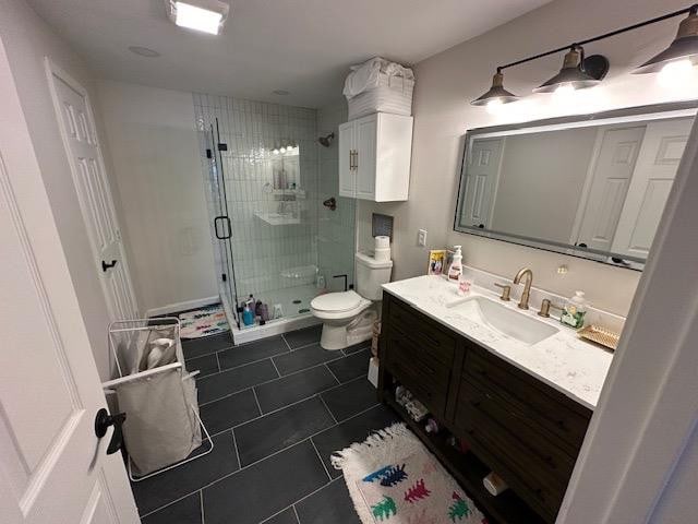 bathroom with vanity, tile patterned flooring, a shower with door, and toilet