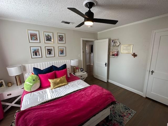 bedroom with ceiling fan, crown molding, dark wood-type flooring, and a textured ceiling