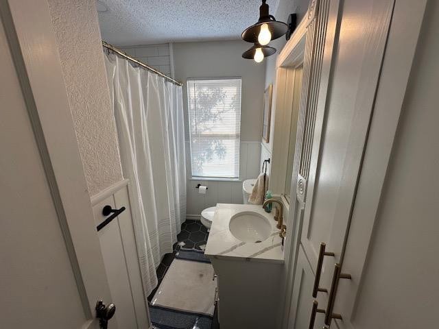 bathroom featuring vanity, toilet, and a textured ceiling