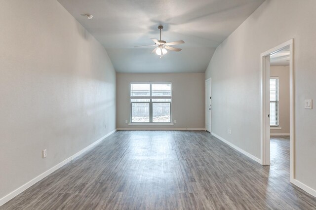 empty room with ceiling fan, dark hardwood / wood-style flooring, and lofted ceiling