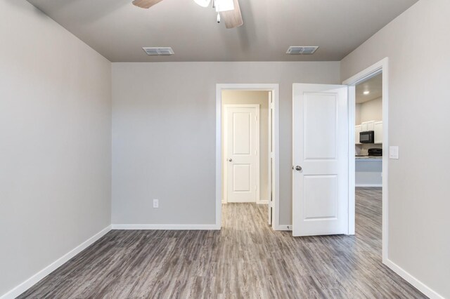 unfurnished bedroom featuring hardwood / wood-style flooring and ceiling fan