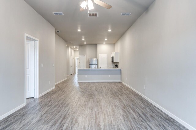 unfurnished living room featuring hardwood / wood-style flooring and ceiling fan