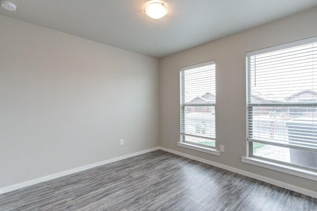 unfurnished room featuring dark hardwood / wood-style floors and a wealth of natural light