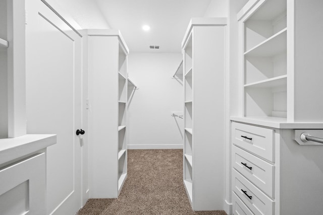 walk in closet with dark carpet