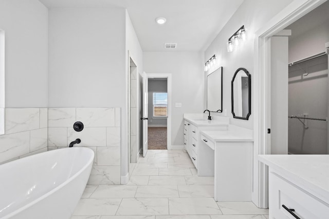 bathroom featuring vanity, tile walls, and a tub