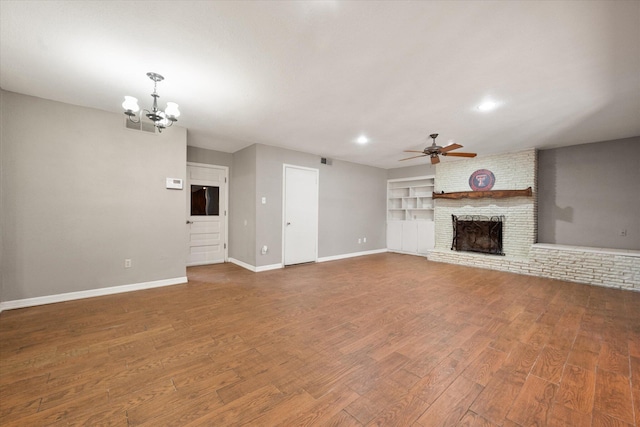 3808 27th St, Lubbock, TX 79410 - unfurnished living room featuring ceiling fan, wood finished floors, a brick fireplace, a chandelier, and recessed lighting