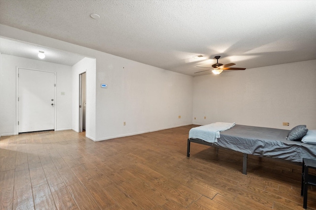 3808 27th St, Lubbock, TX 79410 - bedroom featuring wood finished floors, a textured ceiling, and a ceiling fan