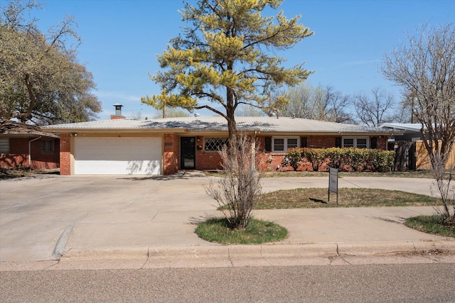 3808 27th St, Lubbock, TX 79410 - single story home featuring curved driveway, brick siding, an attached garage, a chimney, and a metal roof