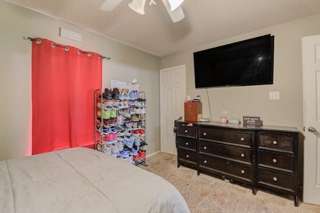 carpeted bedroom with ceiling fan and a textured ceiling