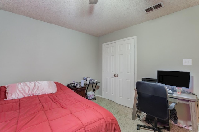 bedroom with ceiling fan and a textured ceiling