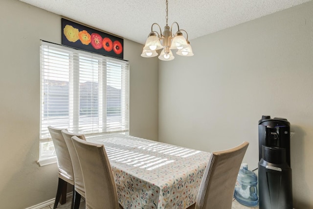 dining area with an inviting chandelier and a textured ceiling