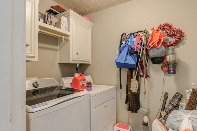 washroom featuring cabinets, washer and dryer, and a textured ceiling