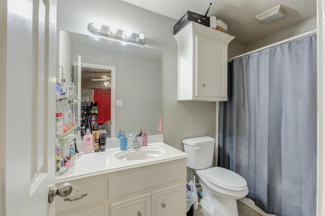 bathroom with vanity, a textured ceiling, and toilet