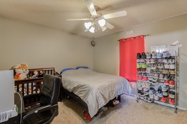 bedroom with ceiling fan, carpet floors, and a textured ceiling