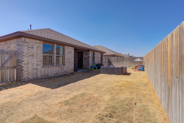 6904 56th St, Lubbock, TX 79407 - rear view of property featuring brick siding, a fenced backyard, and a shingled roof