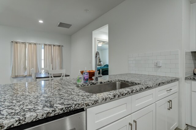6904 56th St, Lubbock, TX 79407 - kitchen with a sink, dishwasher, light stone countertops, white cabinets, and recessed lighting