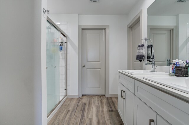 6904 56th St, Lubbock, TX 79407 - full bath featuring a shower stall, double vanity, wood finished floors, and baseboards
