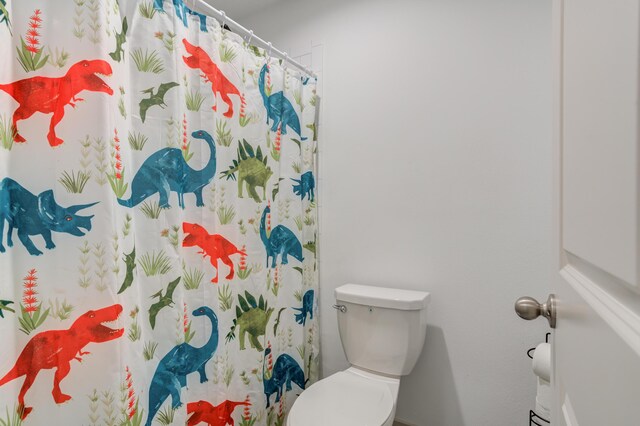 6904 56th St, Lubbock, TX 79407 - bathroom featuring toilet and a shower with shower curtain