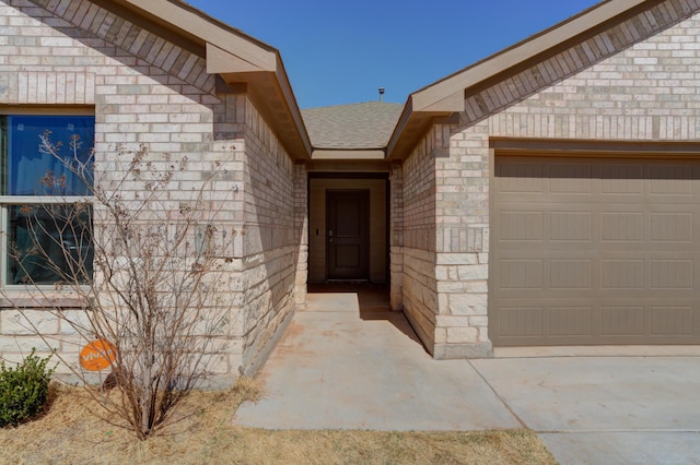 6904 56th St, Lubbock, TX 79407 - view of exterior entry featuring an attached garage and brick siding