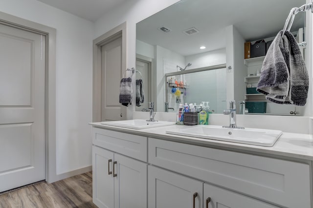 6904 56th St, Lubbock, TX 79407 - full bath with double vanity, a stall shower, wood finished floors, baseboards, and recessed lighting