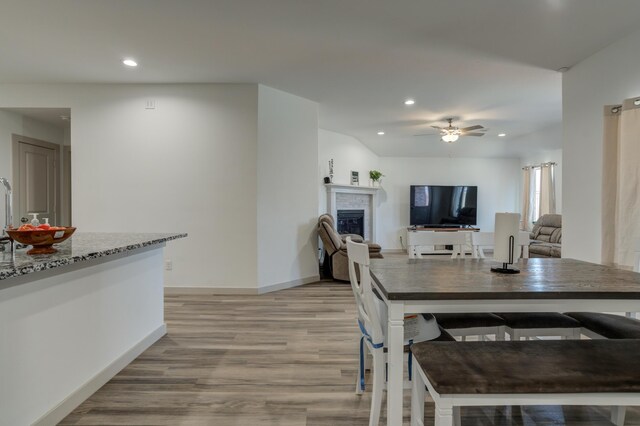 6904 56th St, Lubbock, TX 79407 - dining area featuring light wood finished floors, recessed lighting, a glass covered fireplace, a ceiling fan, and baseboards