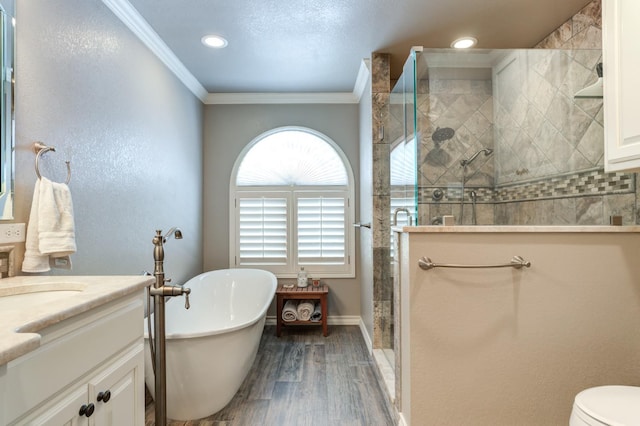 bathroom featuring hardwood / wood-style flooring, ornamental molding, separate shower and tub, and vanity