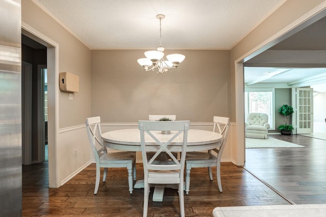 dining space featuring ornamental molding, dark hardwood / wood-style floors, a chandelier, and a textured ceiling