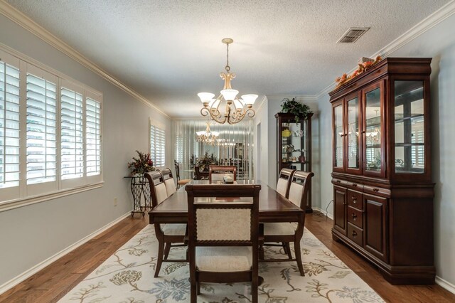 dining room with ornamental molding, dark hardwood / wood-style floors, and a notable chandelier