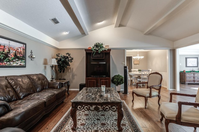 living room with an inviting chandelier, vaulted ceiling with beams, and hardwood / wood-style floors