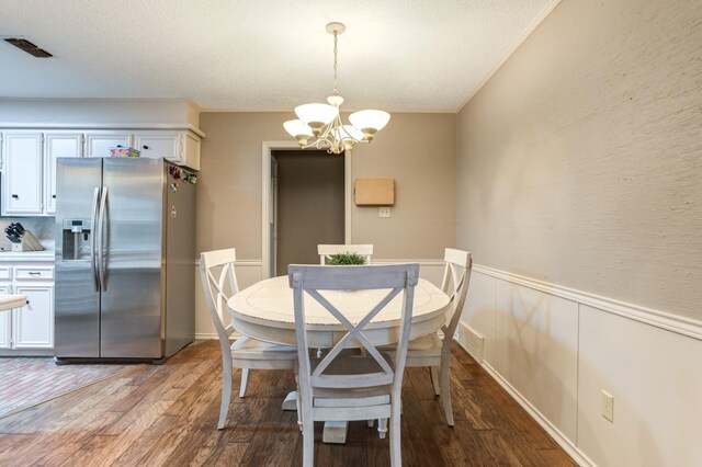 dining area featuring an inviting chandelier, crown molding, and light wood-type flooring