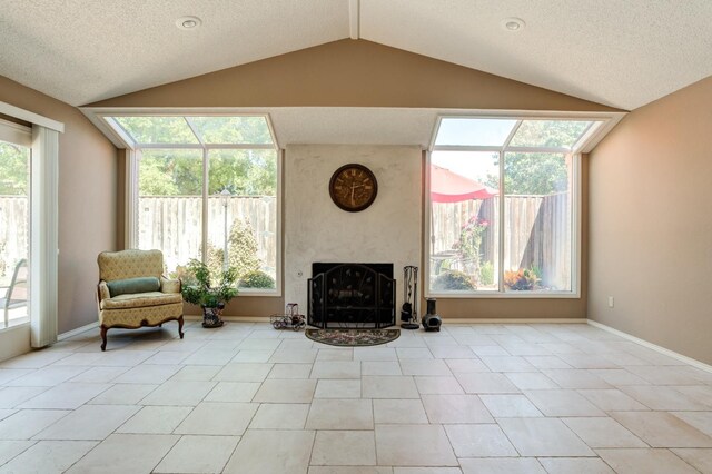 sitting room with vaulted ceiling, a textured ceiling, and light tile patterned floors