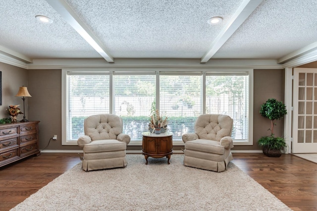 sitting room featuring beam ceiling, dark hardwood / wood-style floors, and a textured ceiling