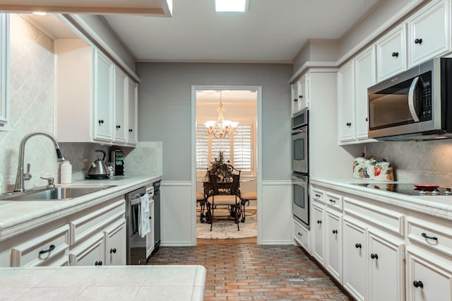 kitchen featuring white cabinetry, sink, backsplash, and appliances with stainless steel finishes