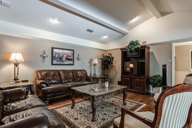 living room featuring lofted ceiling with beams, dark hardwood / wood-style floors, and a textured ceiling