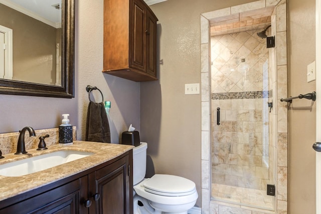 bathroom with vanity, a shower with door, ornamental molding, and toilet