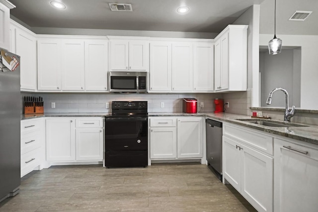 kitchen with white cabinetry, sink, decorative light fixtures, and stainless steel appliances