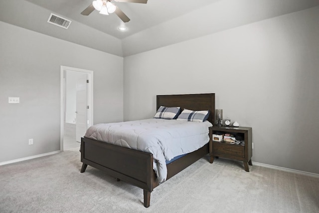 bedroom with vaulted ceiling, light carpet, ceiling fan, and ensuite bath