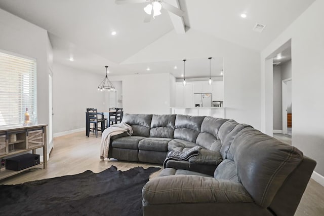 living room featuring lofted ceiling with beams, ceiling fan, and light wood-type flooring