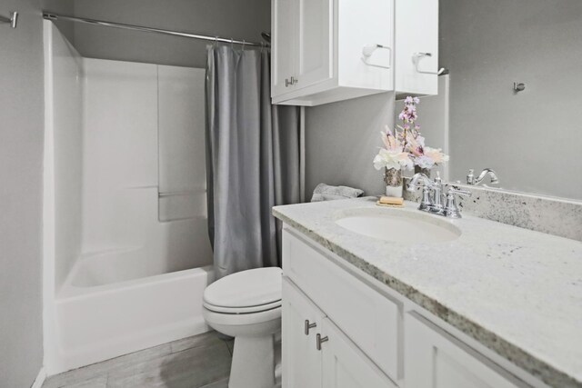 full bathroom featuring vanity, toilet, wood-type flooring, and shower / bath combo with shower curtain