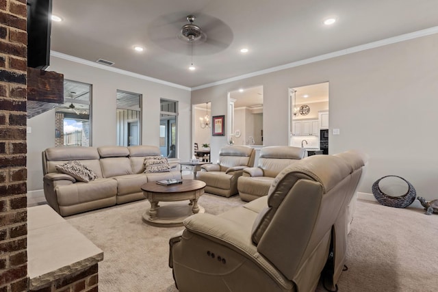 living room featuring a healthy amount of sunlight, ceiling fan, ornamental molding, and carpet